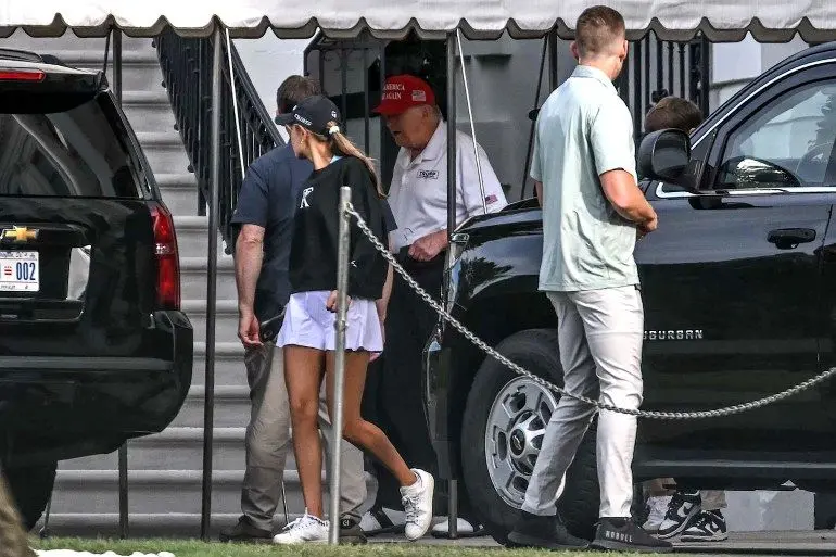 US President Donald Trump (C) and his granddaughter Kai Trump (L) load the motorcade on the south lawn of the White House in Washington DC on August 30, 2025, as they head to Trump National golf course in Sterling, Virginia, (Photo by ANDREW CABALLERO-REYNOLDS / AFP)